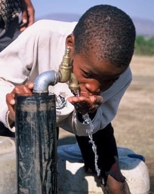 kid drinkiing from tap image