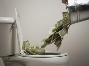 Person dumping money into a toilet bowl