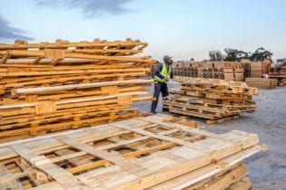 Wellington Kelem, piles up wood at the Struandale plant waste yard. Picture: Quickpic