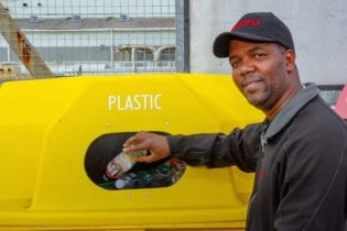 Isuzu employee, Sakhumzi Tsotsi, demonstrates how to dispose of plastic and prevent plastic pollution.