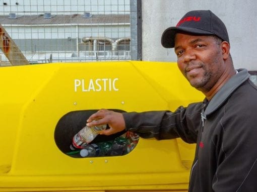 Isuzu employee, Sakhumzi Tsotsi, demonstrates how to dispose of plastic and prevent plastic pollution.