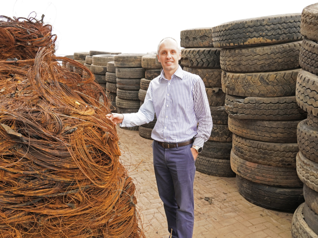 Dr Mehran Zarrebini, CEO of Mathe Group is pictured at the factory in Hammarsdale.  In the foreground is the steel that has been removed from the tyres and in the rear are used tyres waiting to be recycled.