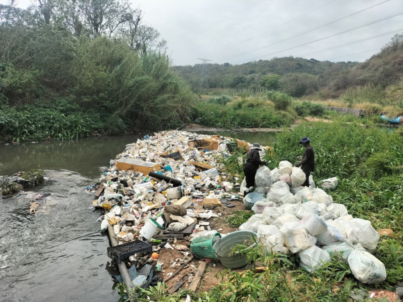 sorting rubbish and litter next to a river system