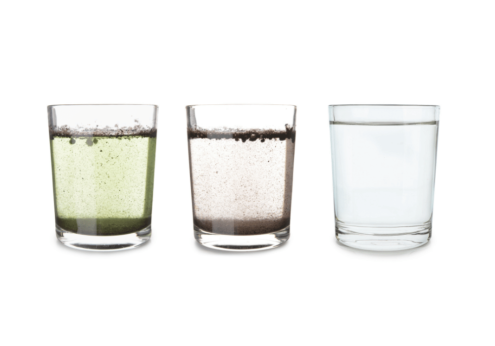 three clear glasses with water samples and water particles