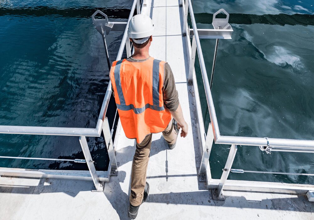 wastewater tanks with engineer walking above the water