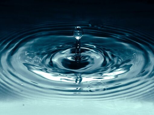 Water droplet into dark blue water pool