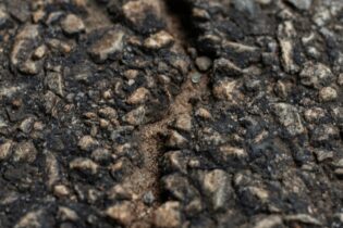 crack in a road exposing cement