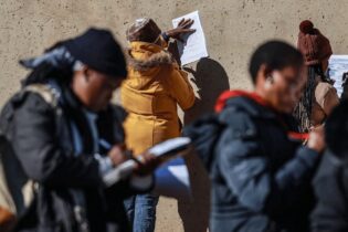 people completing job application forms in the open