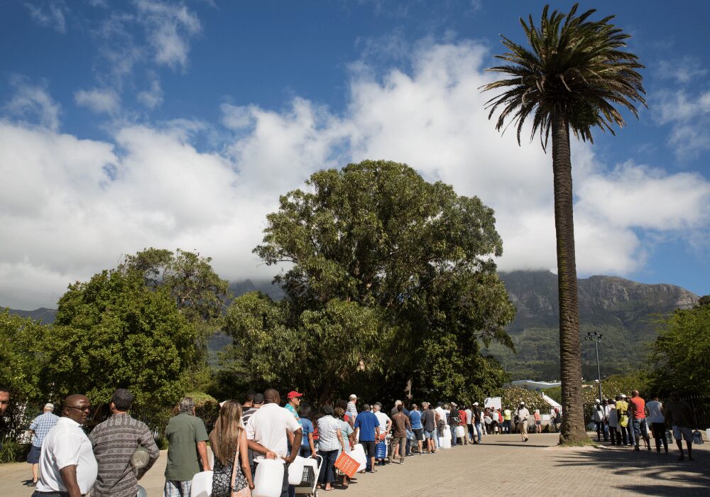 people waiting in line to collect water
