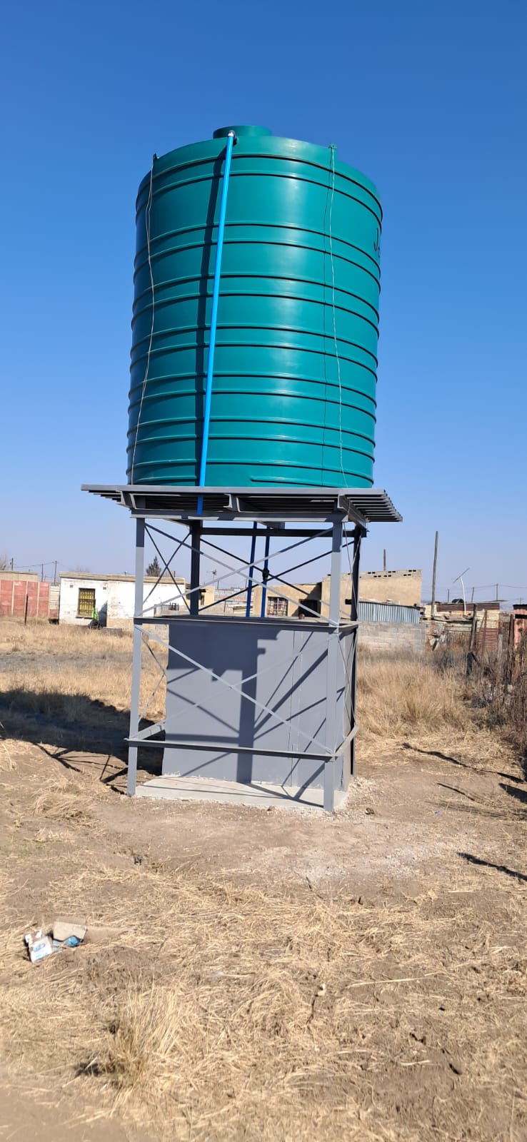 Water tank on metal stand outdoors in rural area