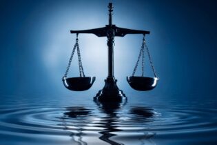 balancing scale ontop of dark blue water