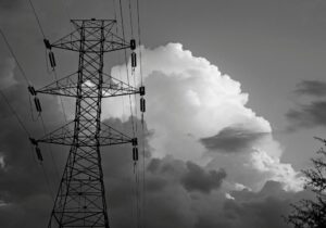 electricity powerline infront of clouds in black and white