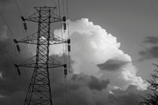 electricity powerline infront of clouds in black and white