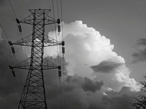 electricity powerline infront of clouds in black and white