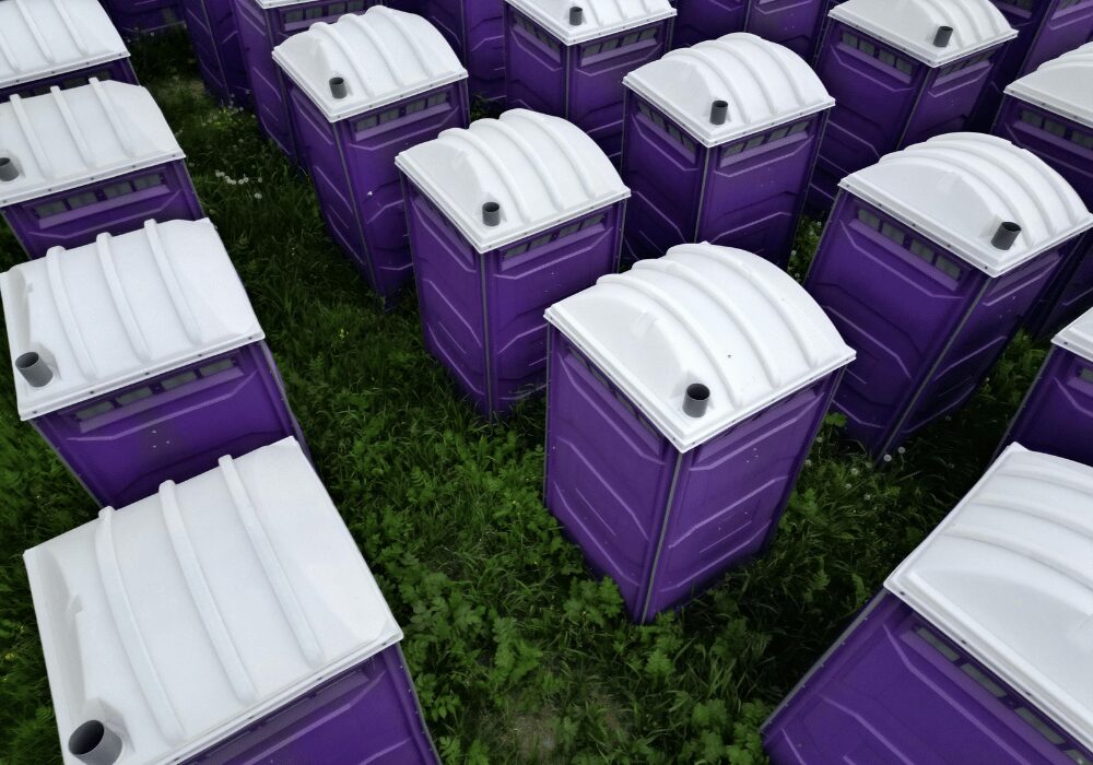 portable purple toilets in a field