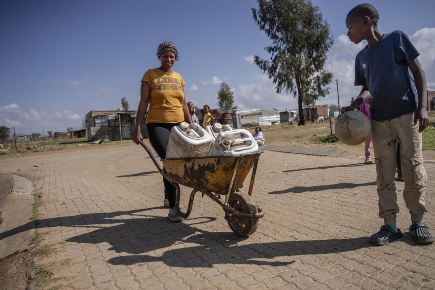 A resident of the informal settlement of Skielik on the outskirts of Delareyville fetches water with a wheelbarrow.