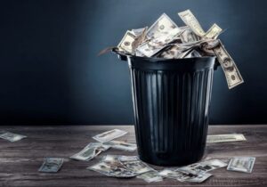 american dollars spilling from a rubbish bin