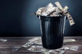 american dollars spilling from a rubbish bin