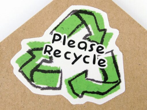 please recycle green sign over a cardboard sheet