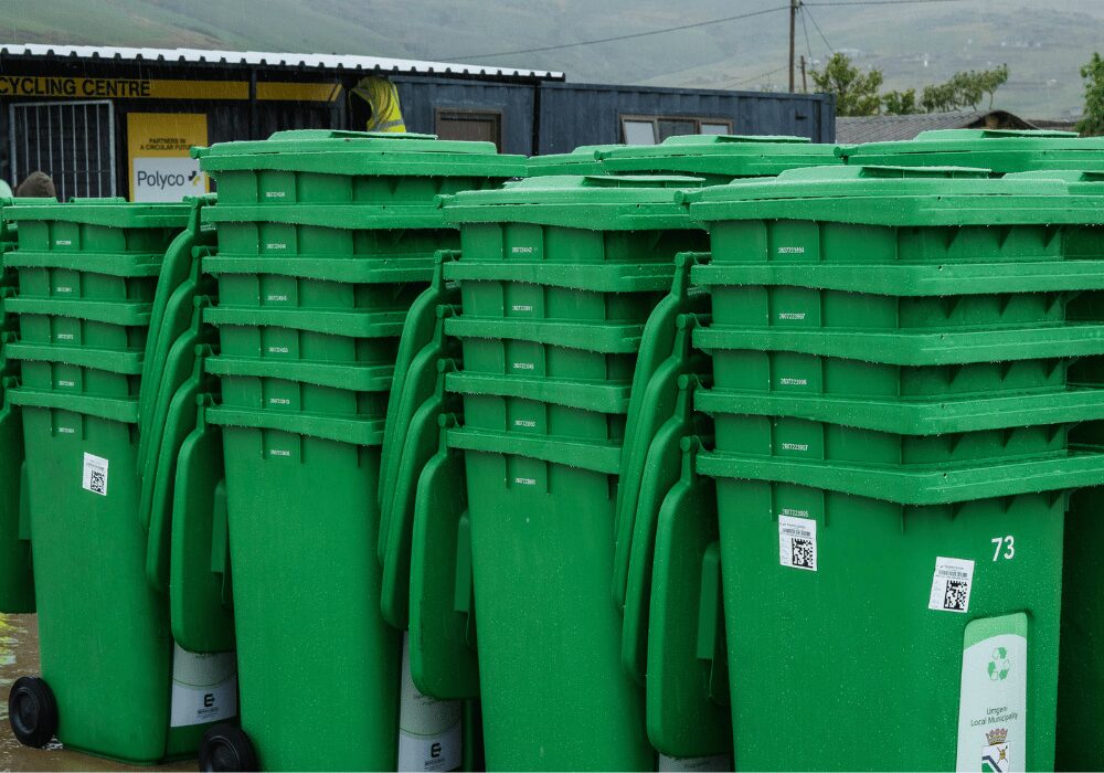 stacked green recycling rubbish bins for polyco recycling centre