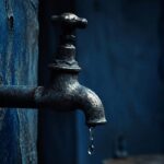 tap running dry in dark blue tones