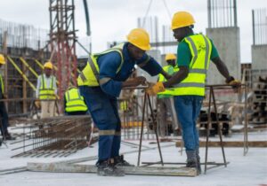 two construction workers on site measuring