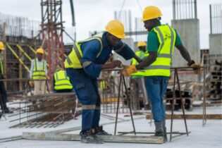 two construction workers on site measuring