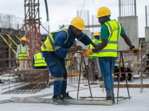 two construction workers on site measuring