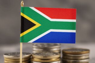 South African flag against a pile of coins