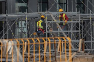 construction site with scaffolding and two construction workers