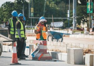 construction workers cementing in concrete blocks on road side