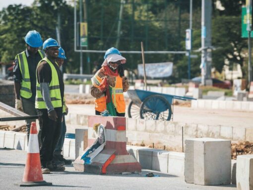 construction workers cementing in concrete blocks on road side