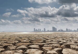 drought land against a city scape with clouds in the background