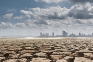 drought land against a city scape with clouds in the background