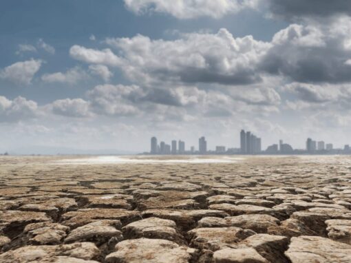 drought land against a city scape with clouds in the background
