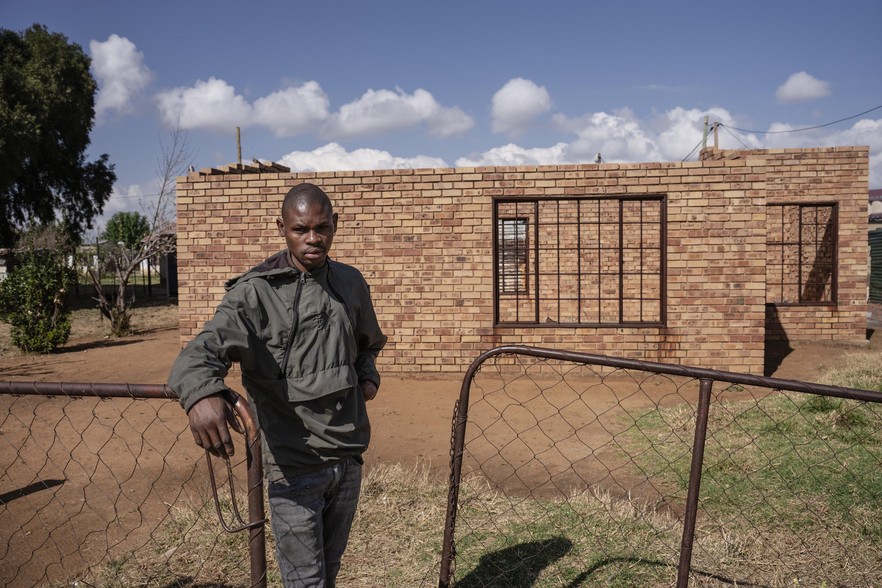 Ganta Shey stands outside his incomplete RDP home in Delareyville.