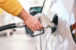 man putting fuel into vehicle