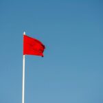 red flag blowing in the wind against a blue background