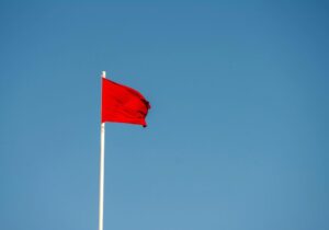 red flag blowing in the wind against a blue background