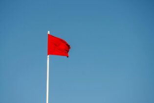 red flag blowing in the wind against a blue background