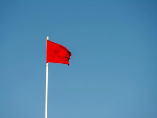 red flag blowing in the wind against a blue background