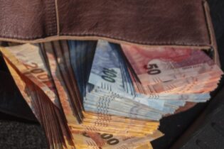 south african rands stacked in a leather wallet